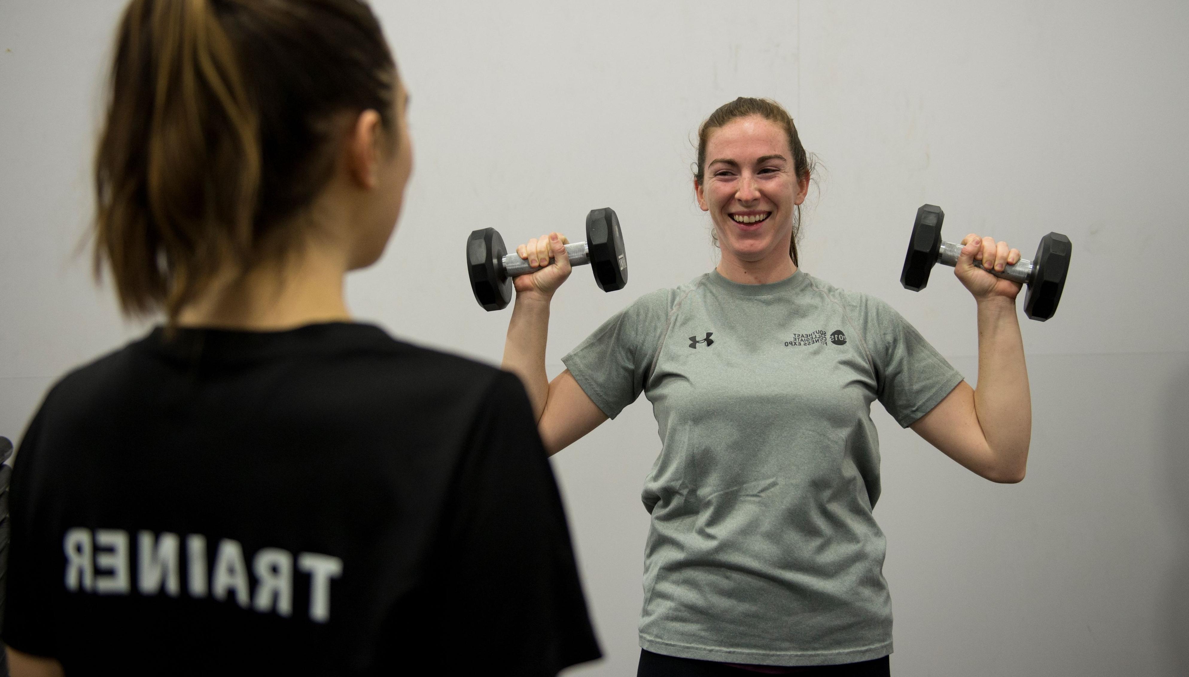 Personal Trainer with someone lifting weights