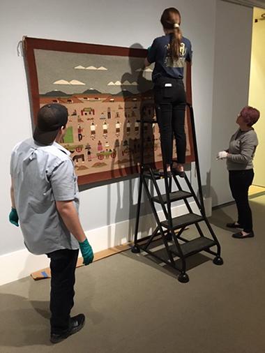 student interns installing exhibition