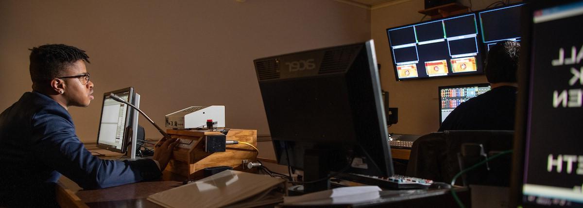 A student uses a microphone in a computer lab. 