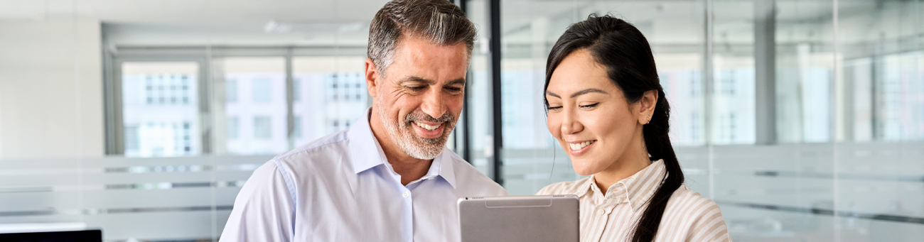 two people standing looking at a notebook