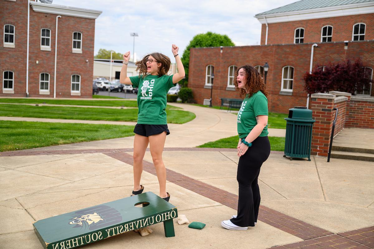 two students playing corn hole