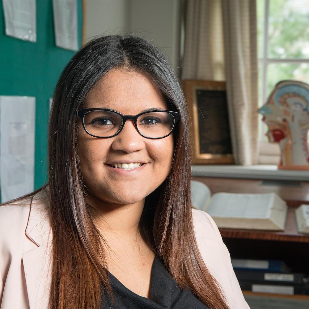 A student poses for a photo in a classroom.