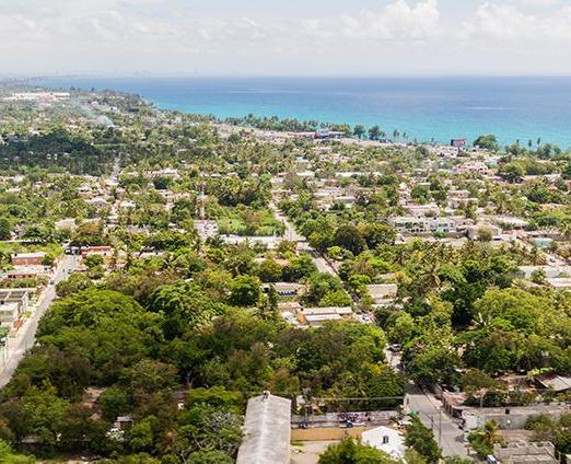 Overview of tree filled city with the coastline in the upper left corner. 