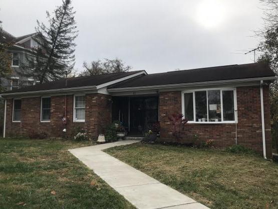 Brick ranch-style home with bay window, sidewalk through lawn to front door